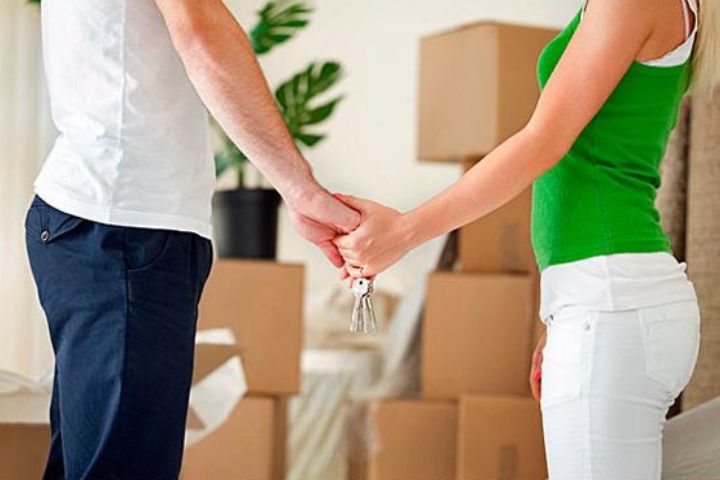 couple holding hands with keys to new house