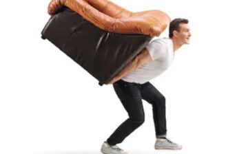 man carrying an armchair on his back