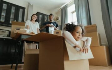 child seats inside a box and parents watching