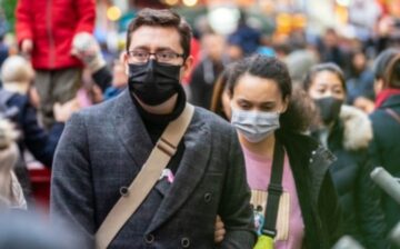 couple walking down the street with a mask