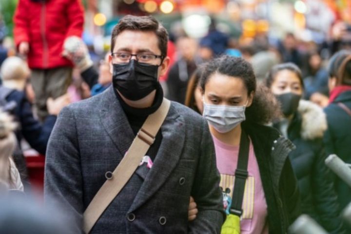 couple walking down the street with a mask
