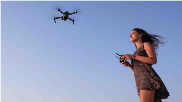 young woman operating a drone by remote control