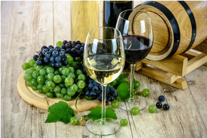 wine grapes, a barrel, and wine glasses