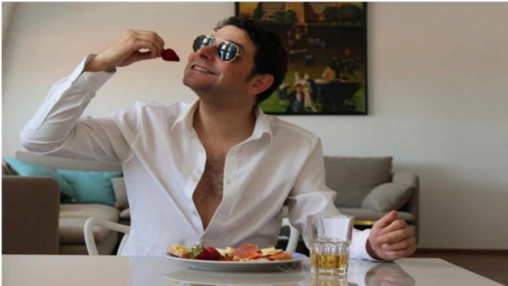 man eating fruit at glass table