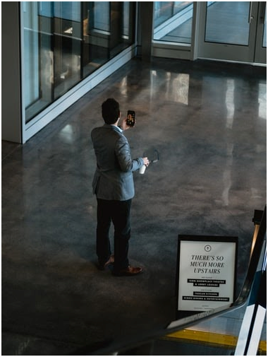 man looking at a cell phone in a building lobby