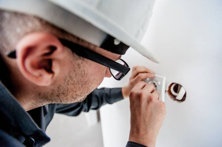 electrician installing a timer switch in a wall