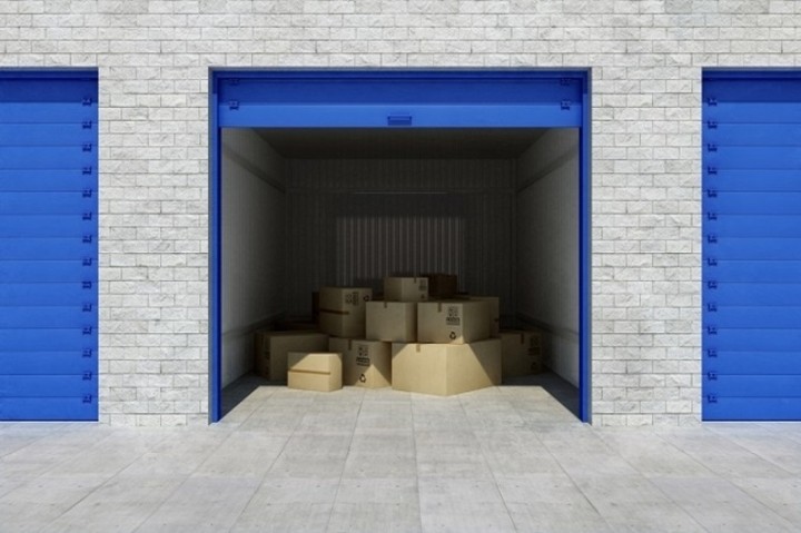 storage facility with one unit open showing cardboard boxes inside