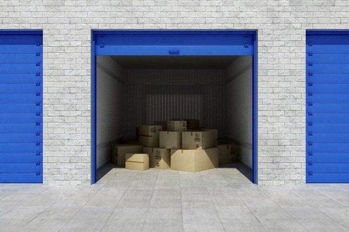 storage facility with one unit open showing cardboard boxes inside