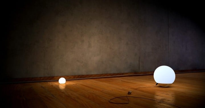 two lighted globes in a darkened room with wood floor