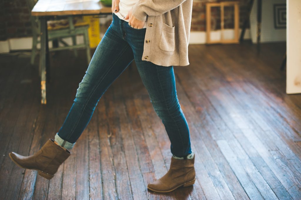 woman walking with boots over a hardwood floor