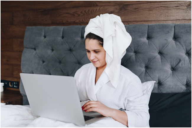woman on laptop while sitting in bed
