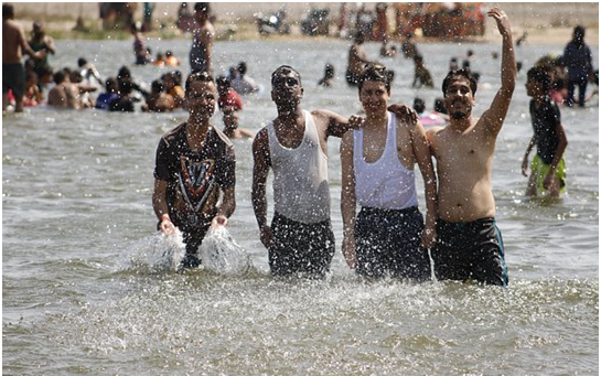 four young friends standing together in water