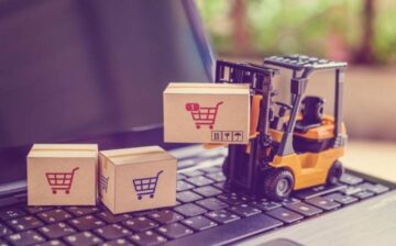 toy forklift lifting boxes on a computer keyboard