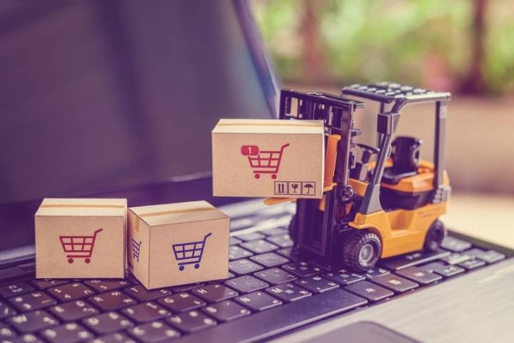 toy forklift lifting boxes on a computer keyboard