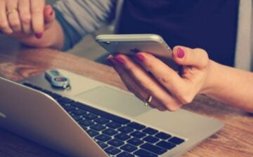 woman with laptop, smartphone, and USB drive