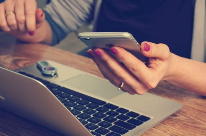 woman with laptop, smartphone, and USB drive