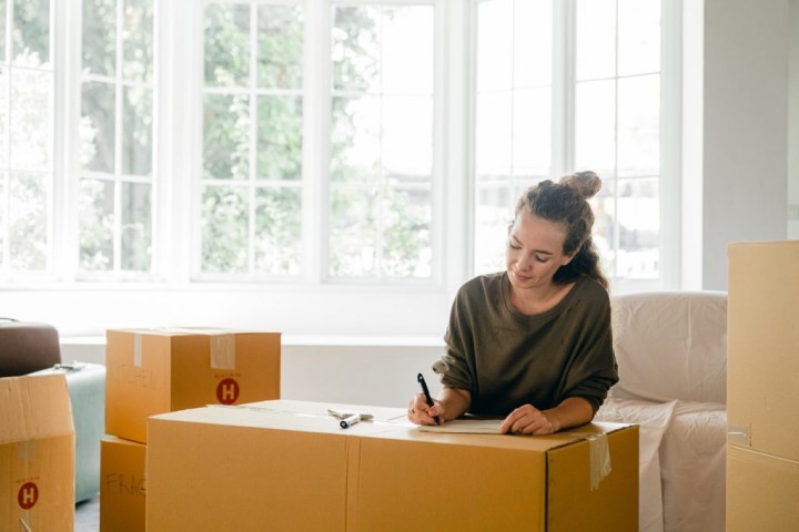 woman labeling moving boxes