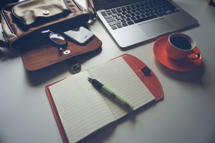 image of briefcase, laptop, notebook with pen, and coffee cup