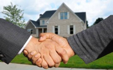 handshake in front of a house