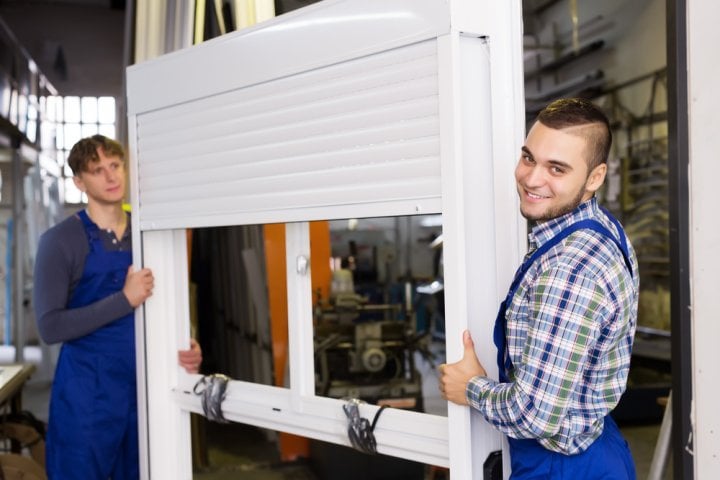 man and woman carrying roller shutter