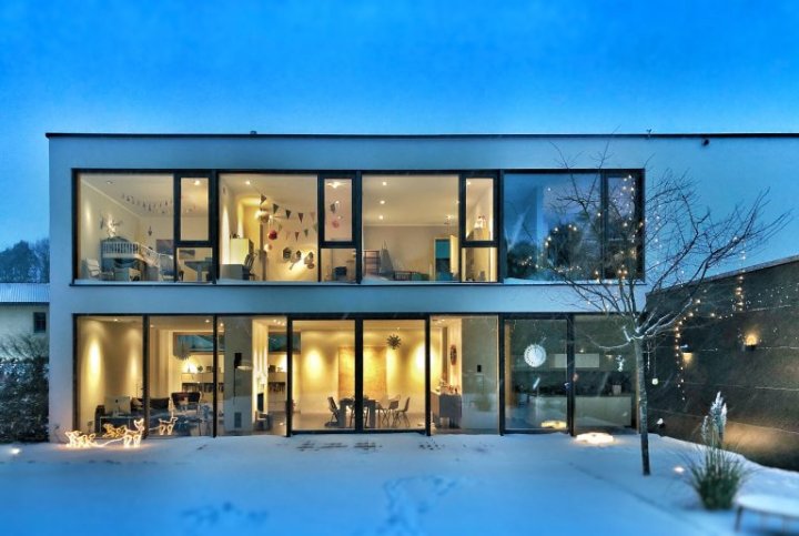 exterior of home in winter with brightly lit rooms
