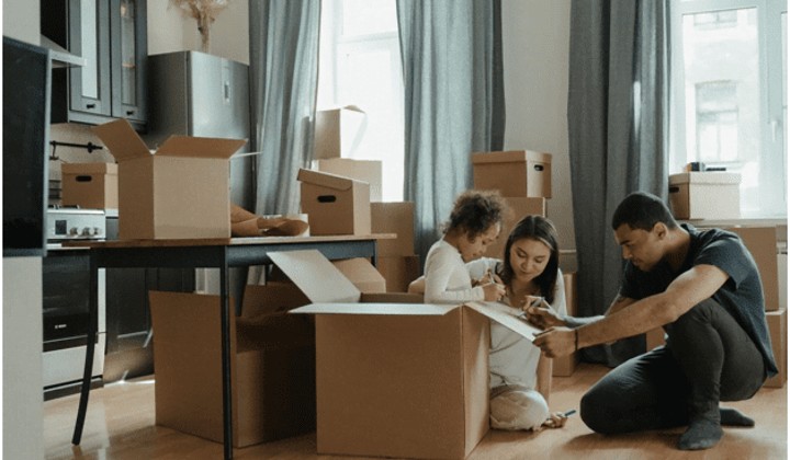 family packing moving boxes and writing box