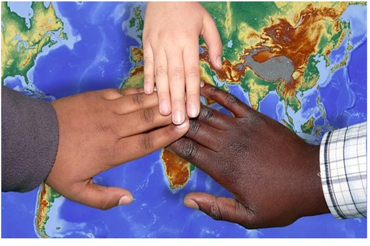 hands joined with world map