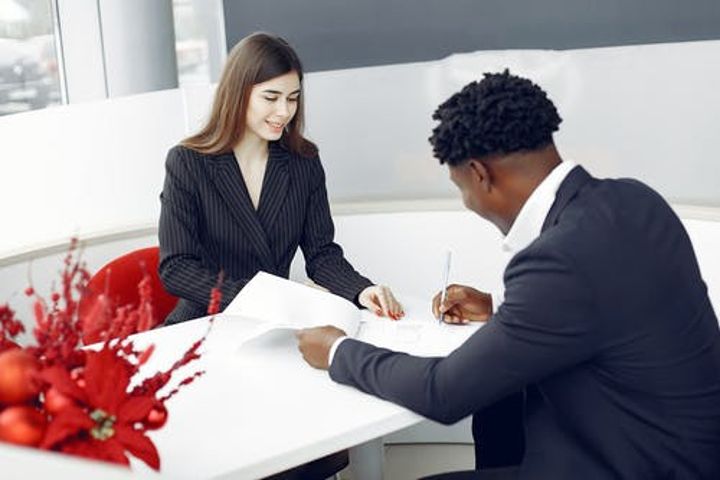 man and woman signing sale of house