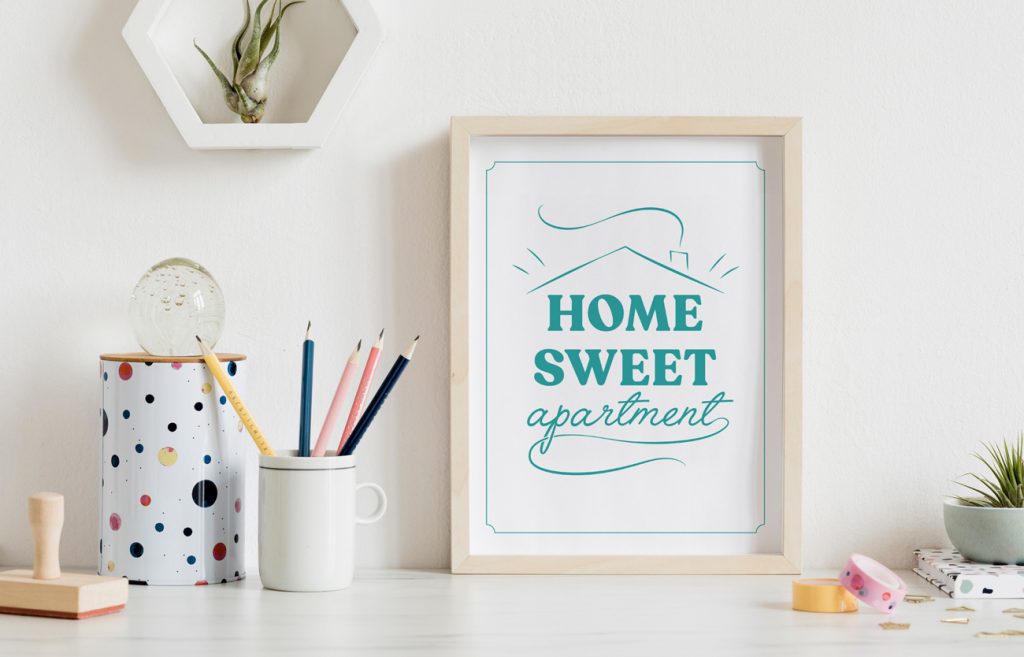desk with "home sweet apartment" sign