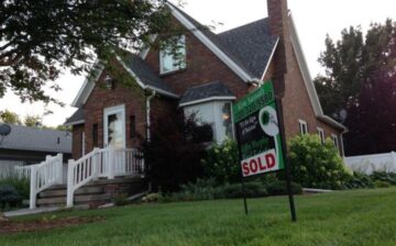 house with sold sign on front lawn