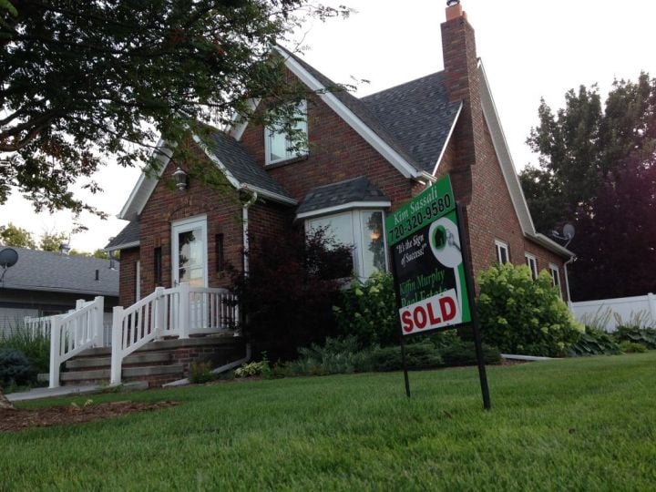 house with sold sign on front lawn