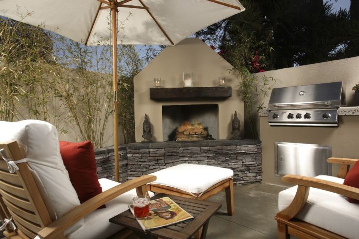 patio with furniture, umbrella, fireplace, and grill