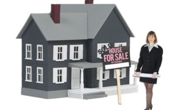 realtor in front of model of home for sale