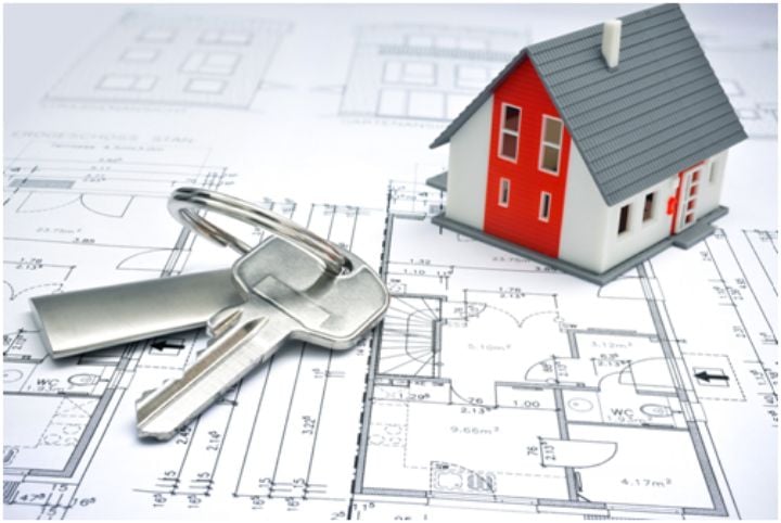 model of a house and keys on top of a blueprint