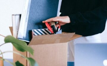 woman packing box of office supplies and books
