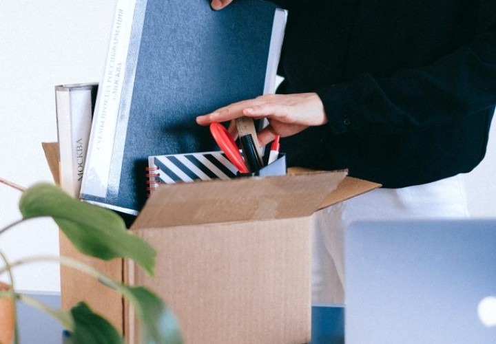 woman packing box of office supplies and books