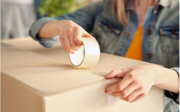 woman sealing a packing box