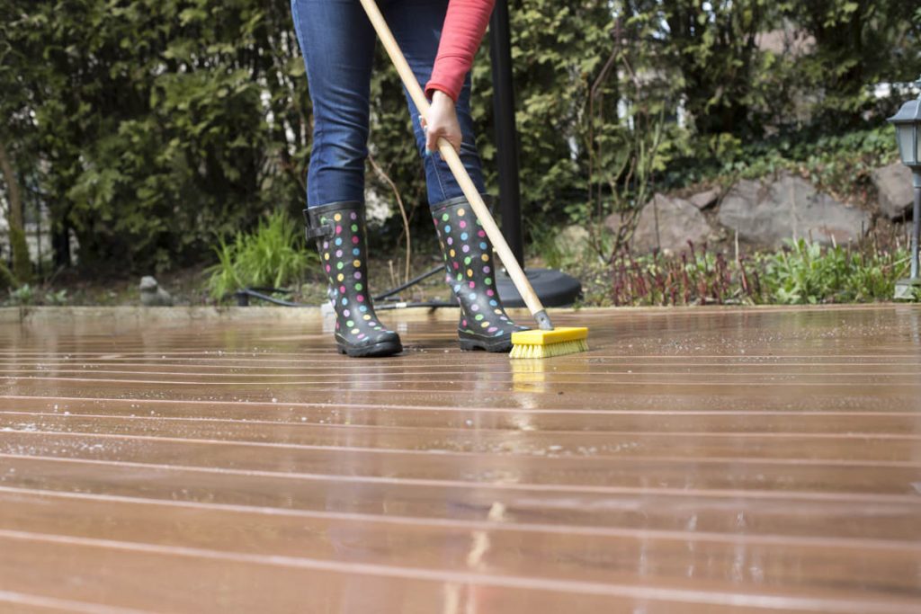cleaning deck with water and a brush