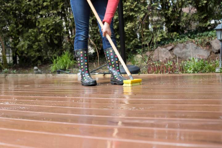 woman cleaning terrace deck