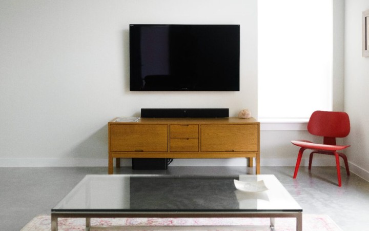 TV mounted on wall with cabinet and coffee table