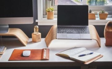 home office desk with laptop, PC, and notebook