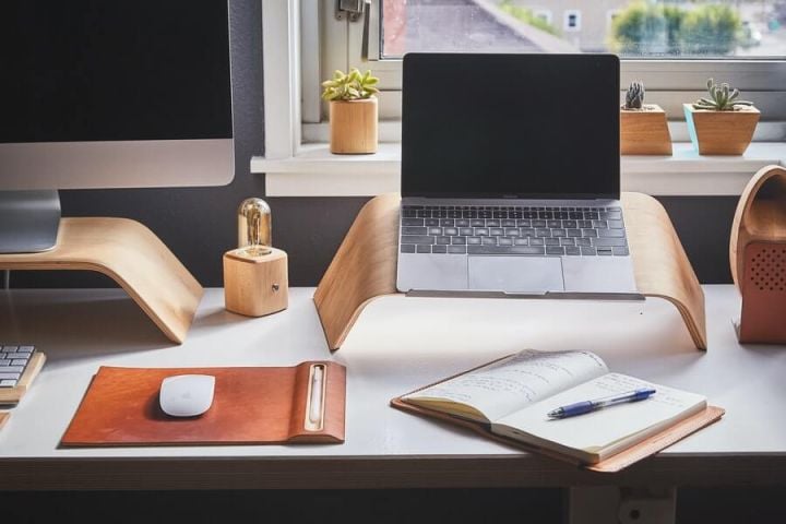 home office desk with laptop, PC, and notebook