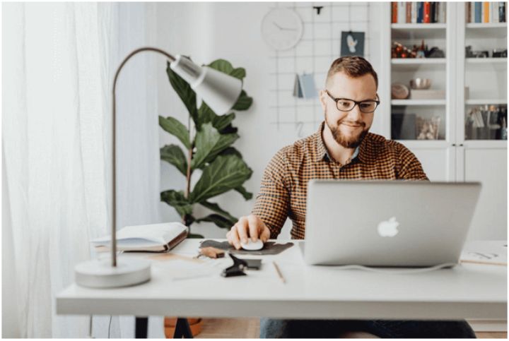 man sitting at a desk working on a laptop