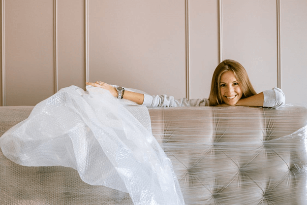 woman unwrapping a sofa