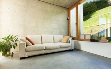 living room with large window, sofa, and concrete floor