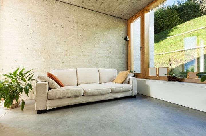 living room with large window, sofa, and concrete floor