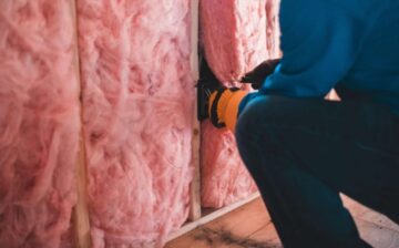 man arranging thermal insulation on a wall