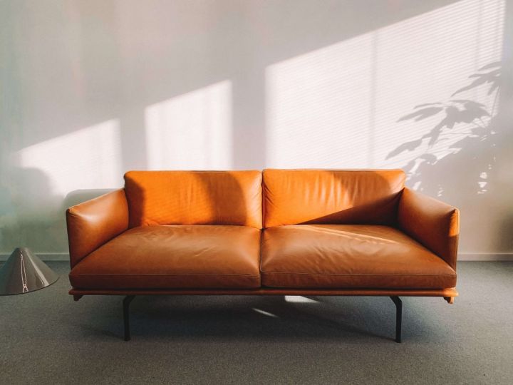 light brown sofa in front of a white wall