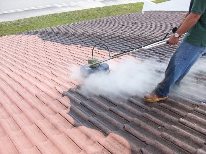 man cleaning a roof with a scrubbing device