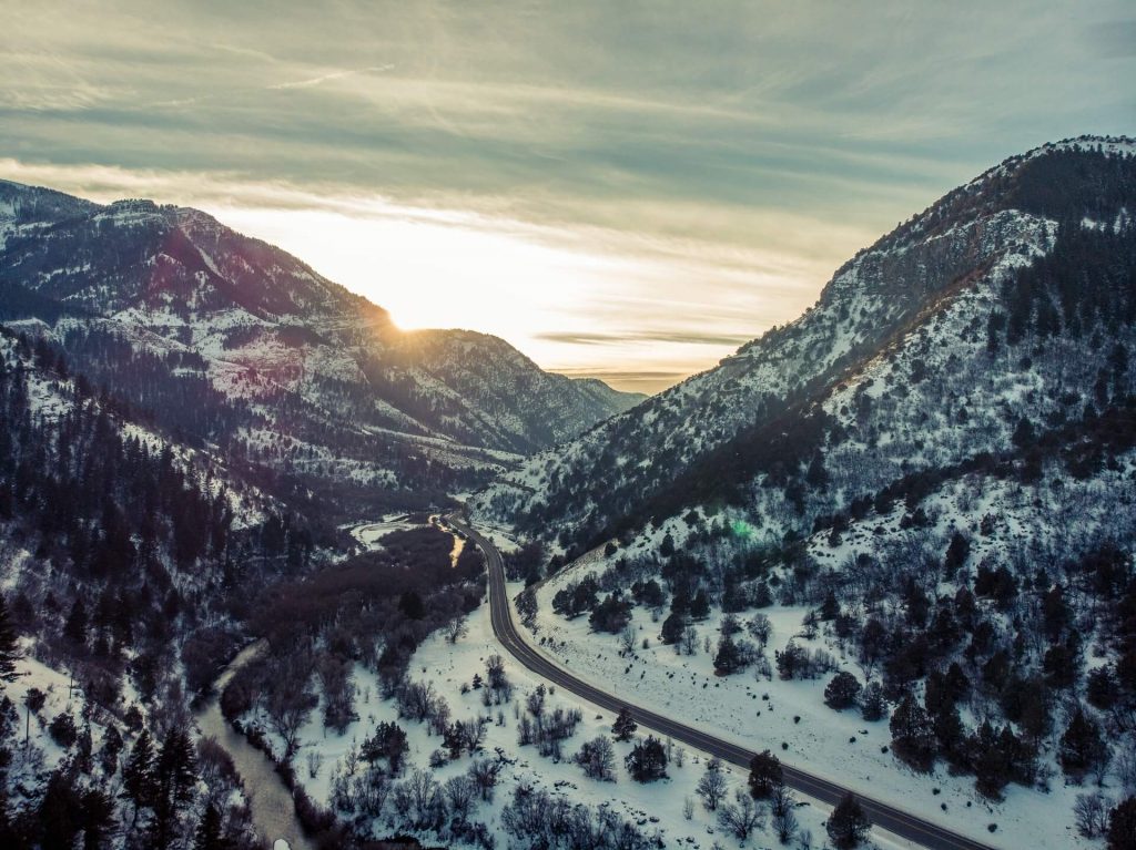 two-lane road through snowy Utah mountains